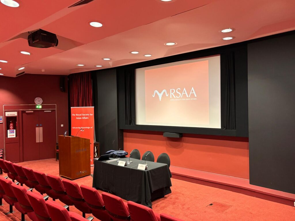 An auditorium with an RSAA banner and projected logo